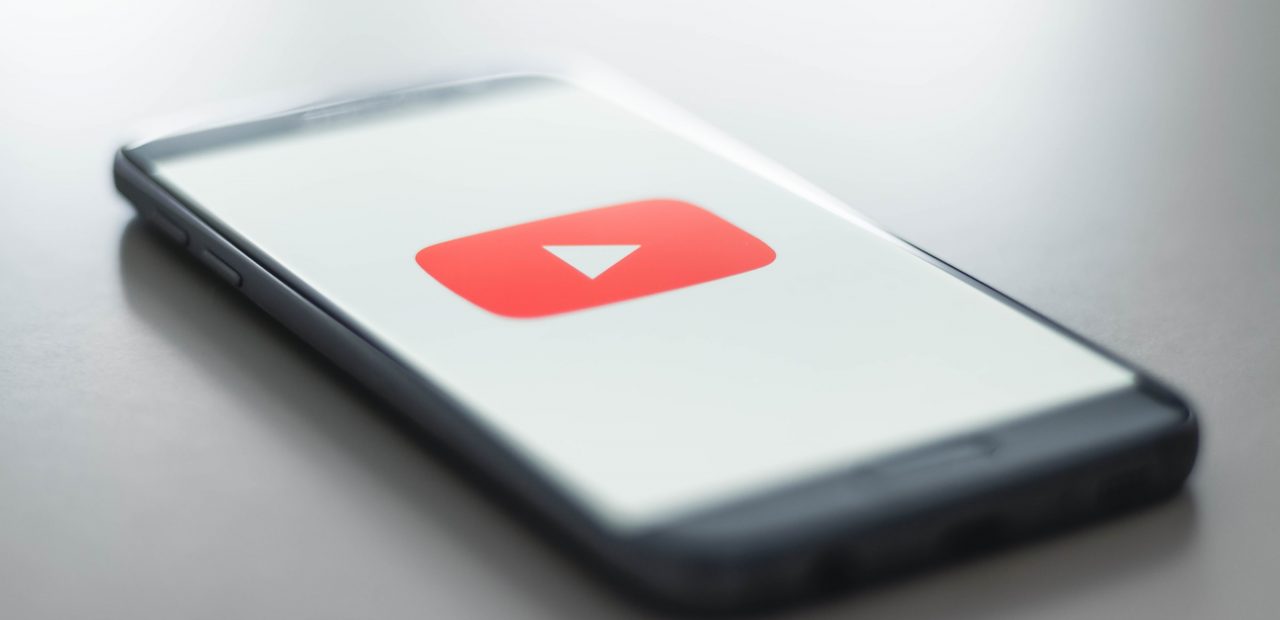 Logo serwisu YouTube na ekranie nowoczesnego telefonu